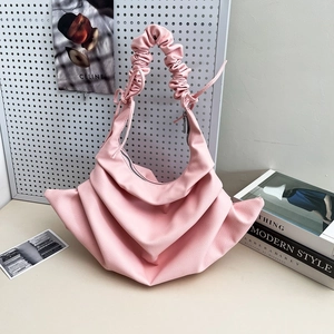 Pink pleated crossbody bag with gathered handle and fan-shaped minimalist design