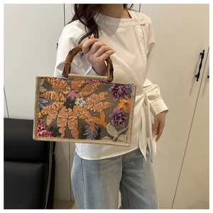 Detail of embroidered bohemian tote bag featuring handmade sequins and natural bamboo handles