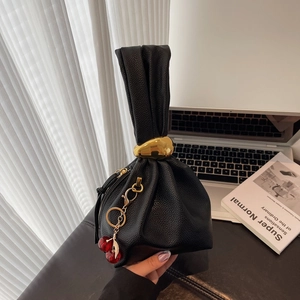 Chic black lychee grain leather handbag with ruched handle and cherry charm pendant