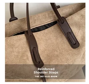 Gros plan des bretelles renforcées et des coutures sur un sac cabas en daim bicolore