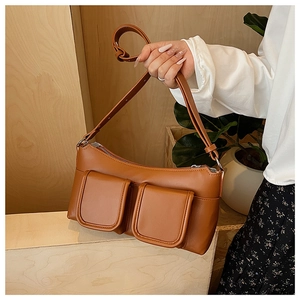 Close-up of brown faux leather shoulder bag with double pockets and silver metal hardware