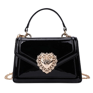 Chic black patent leather crossbody bag with vintage gold heart buckle and pearls
