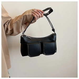 Detail of a black PU leather underarm bag with front flap pockets and adjustable strap