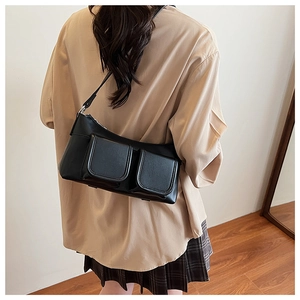 Close-up of black PU leather crossbody bag with dual front magnetic pockets and strap