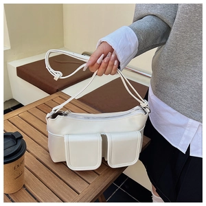 Detail of white PU leather shoulder bag featuring symmetrical double front flap pockets