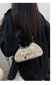 Detailed view of silver liquid metal texture handbag with metallic handle and clasp