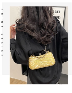 Detail of yellow wave print evening bag with pearl rhinestone clasp and gold chain strap