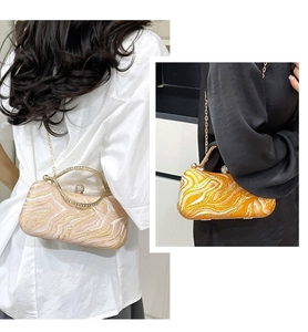 Detailed shot of marbled evening clutch with sparkling rhinestone metal handle and gold chain