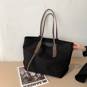 Sac cabas minimaliste en daim noir avec anses en cuir marron pour un style automnal
