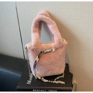 Dettaglio borsa peluche rosa con catena dorata, ciondolo di perle e foulard in seta fiorita