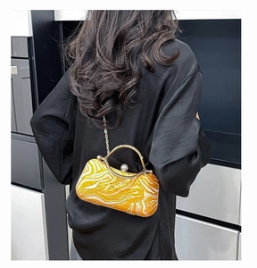 Detail of orange marble pattern evening bag with rhinestone handle and pearl clasp