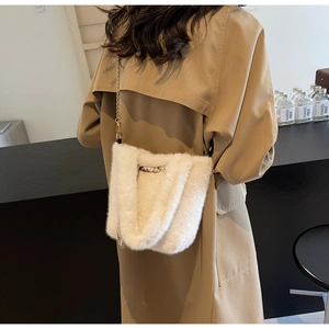 Dettaglio borsa di peluche bianco panna con catena dorata e decorazioni di perle