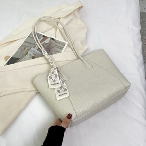 Close-up of cream tote bag with litchi grain leather and checkered fashion scarf