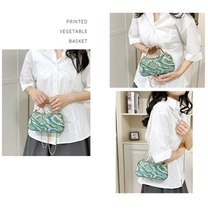 Detailed view of green and white printed evening bag with gold chain and handle