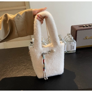 Dettaglio borsa a secchiello in ecopelliccia bianca con perle, foulard e catena dorata