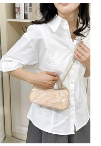 Detailed close-up of pink and white fluid marble pattern evening bag with gold glitter finish