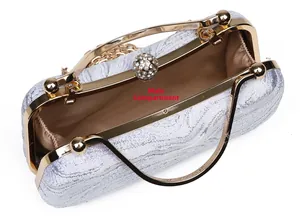 Detail of silver jacquard evening bag showing the main pocket and gold metal handle