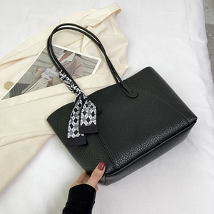 Close-up of black litchi leather tote bag featuring a decorative checkered silk scarf