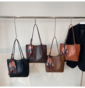 Détail de quatre sacs fourre-tout vintage en similicuir avec foulards en soie décoratifs