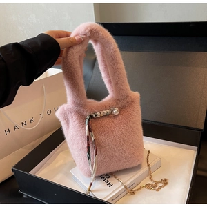 Dettaglio borsa rosa di peluche con foulard di seta, perla e catena dorata