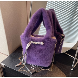 Dettaglio borsa in ecopelliccia viola con catena dorata e decoro foulard in seta floreale
