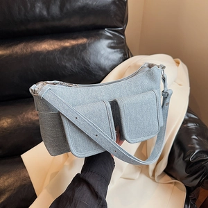 Minimalist light blue denim crescent underarm bag with utilitarian flap pockets for women