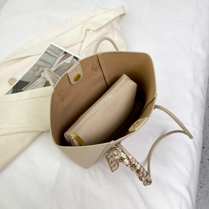 Close-up of apricot tote bag with textured leather, gold magnetic buckle and silk scarf
