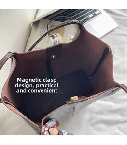 Vue détaillée du fermoir magnétique et du foulard en soie sur le sac fourre-tout