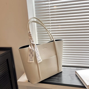 Detail of cream white lychee leather tote bag with a floral fashion scarf handle