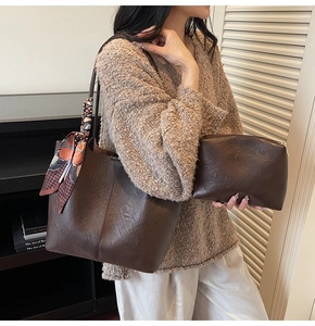 Détail du sac cabas marron foncé avec foulard décoratif et pochette assortie sur l'anse