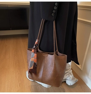 Détail du sac cabas vintage marron avec foulard en soie géométrique sur la poignée