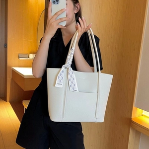 Detail of white lychee pattern tote bag with decorative fashion scarf on handle