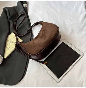 Détail des coutures en daim et cuir marron foncé sur le sac hobo minimaliste