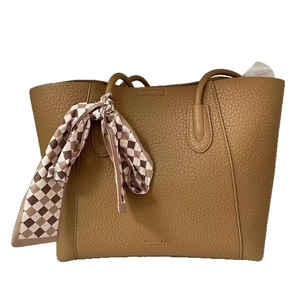 Brown lychee leather tote bag for women with a decorative checkered silk scarf on the handle