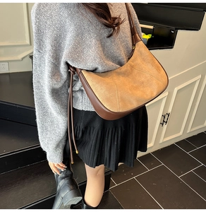 Détail du sac hobo en daim kaki et cuir marron orné d'un long gland décoratif élégant