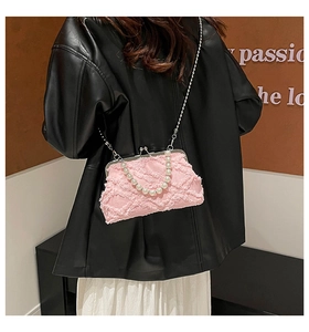 Detail of pink frayed canvas bag with pearl handle and silver chain strap
