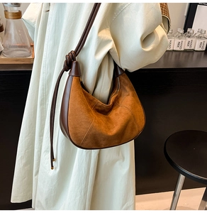 Gros plan du sac en daim marron avec bordure en cuir et bandoulière nouée à la main
