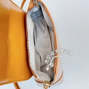 Interior view of vintage shoulder bag with grey herringbone lining and zipper pocket