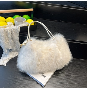 Détail de la texture d'un sac à main blanc en fausse fourrure avec de fines anses en cuir