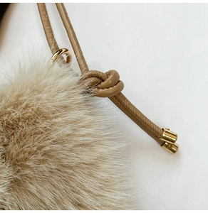Détail du sac en peluche camel avec texture en fausse fourrure et cordon en cuir noué