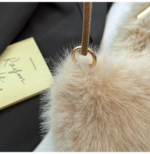 Gros plan du sac en fausse fourrure avec anneau en métal doré et bandoulière en cuir brun