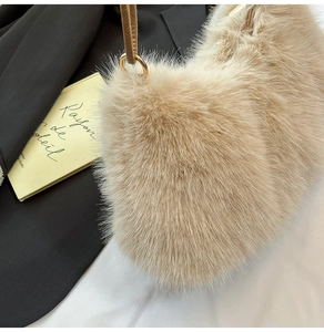 Détail du sac bandoulière en peluche beige avec fermoir en métal doré brillant