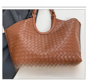Detailed close-up of premium brown woven leather texture and sturdy metal hardware