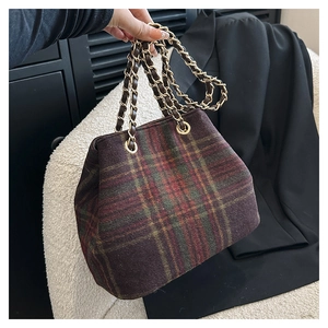 Detail of vintage plaid wool shoulder bag with red-green tartan pattern and gold chain strap
