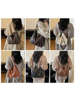 Detail view of large capacity crossbody bags in brown, white, orange and black colors