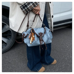 Détail du sac seau en toile bleue avec bordure en cuir marron et perles en bois