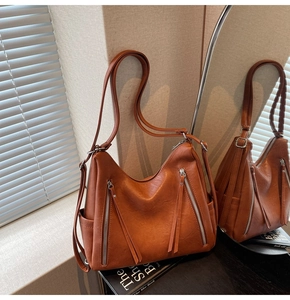 Detail view of caramel brown vintage hobo bag with fringe zippers and adjustable strap