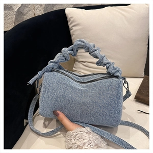 Light blue denim handbag with ruched handle and adjustable strap for shoulder wear