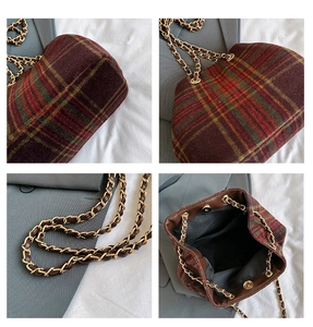 Detail view of plaid wool bucket bag showing gold chain strap and magnetic closure