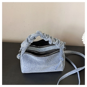 Macro shot of light blue denim fabric texture and double zipper detail on handbag